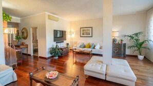 Una sala de estar con sofá, mesa de centro, televisión y chimenea.