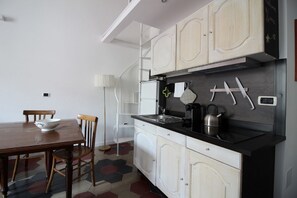 Una cucina con mobili bianchi, un piano di lavoro nero e un tavolo da pranzo con sedie.