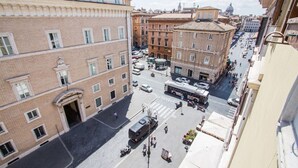 A street-level view of a city with buildings, a bus, and pedestrians. - Relax Apartment Navona Sq. (Roma)