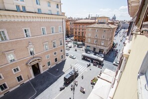 Una vista dal livello della strada di una città con edifici, un autobus e pedoni.