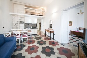 A compact living space with a dining area, kitchenette, and a sofa. - Relax Apartment Navona Sq. (Roma)