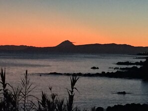 A coastal landscape with a mountain silhouette against a sunset sky. - Traditional Angra House (Angra do Heroísmo)