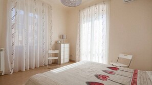 Quarto com uma cama, uma escrivaninha e uma cadeira.