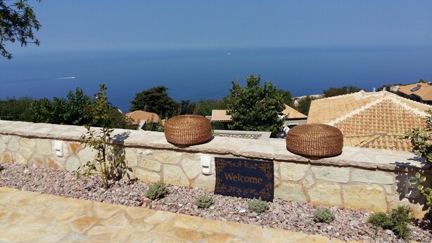 Een stenen muur met een welkomstmat en twee gevlochten manden.