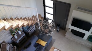 Een moderne woonkamer met een trap, een open haard en een televisie.
