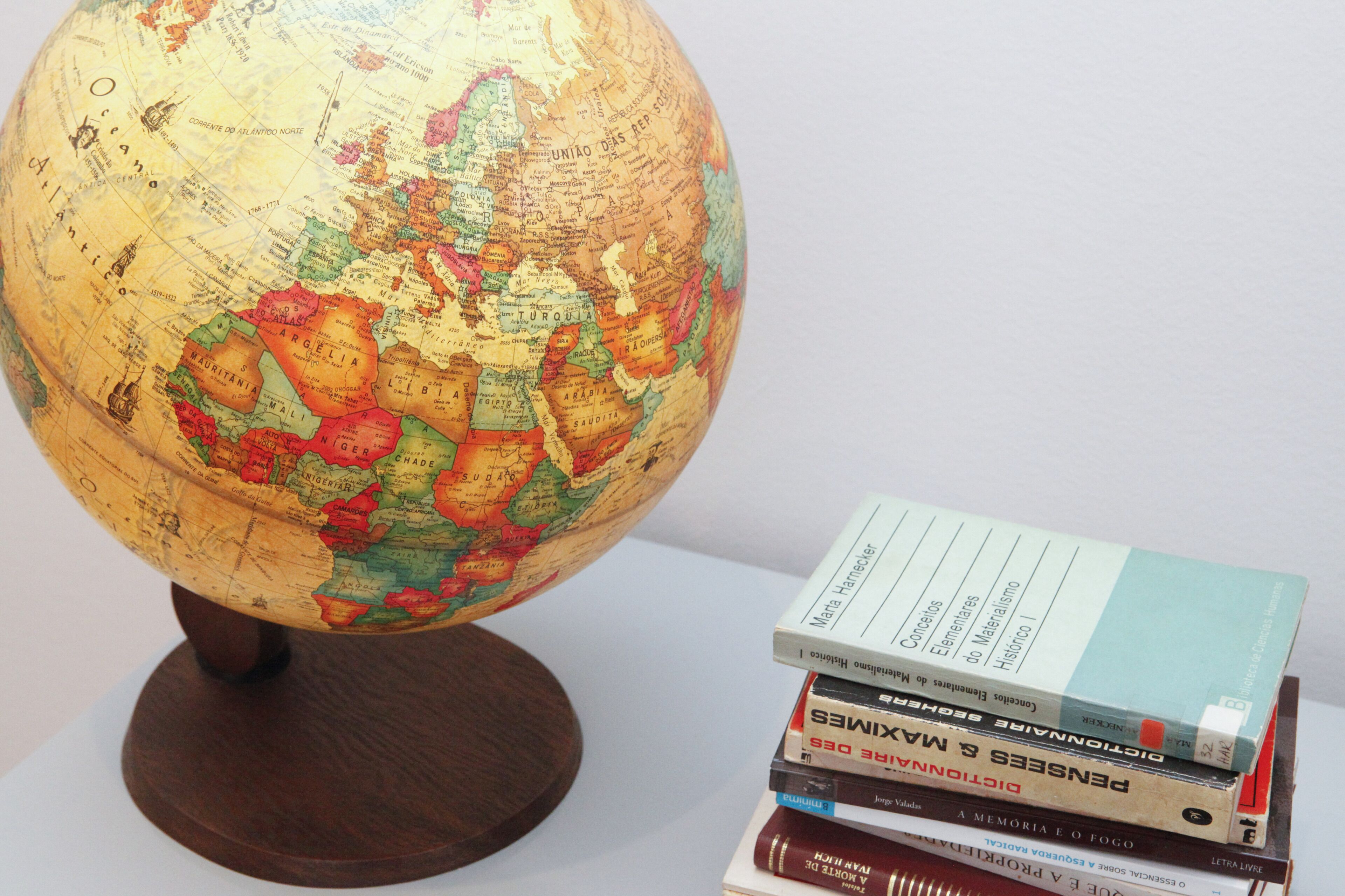 Ein Globus mit Holzständer und ein Bücherstapel daneben.