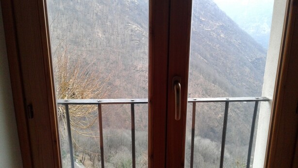 Un balcon doté d’une rambarde en métal et d’une porte en bois.