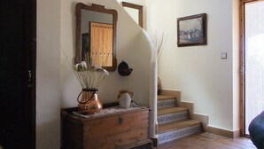 Una escalera con barandilla de madera y una pared blanca con un cuadro enmarcado.