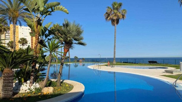 A swimming pool with palm trees and a view of the ocean. - Mi MI CAPRICHO LUXURY APARTMENT P.11 (Mijas)