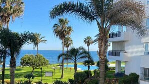 A resort with a pool, palm trees, and a view of the ocean. - Mi MI CAPRICHO LUXURY APARTMENT P.11 (Mijas)