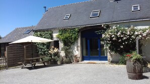 A house with a blue door, a small window, and a wooden fence. - 4-person gîte in farmhouse - heated indoor swimming pool  (Évellys)
