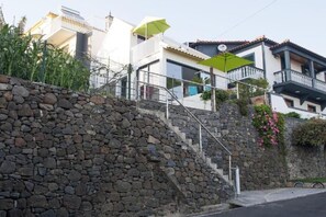 A residential area with a stone staircase leading to a modern house with a balcony. - House Crystal Calheta (Calheta (Madeira))