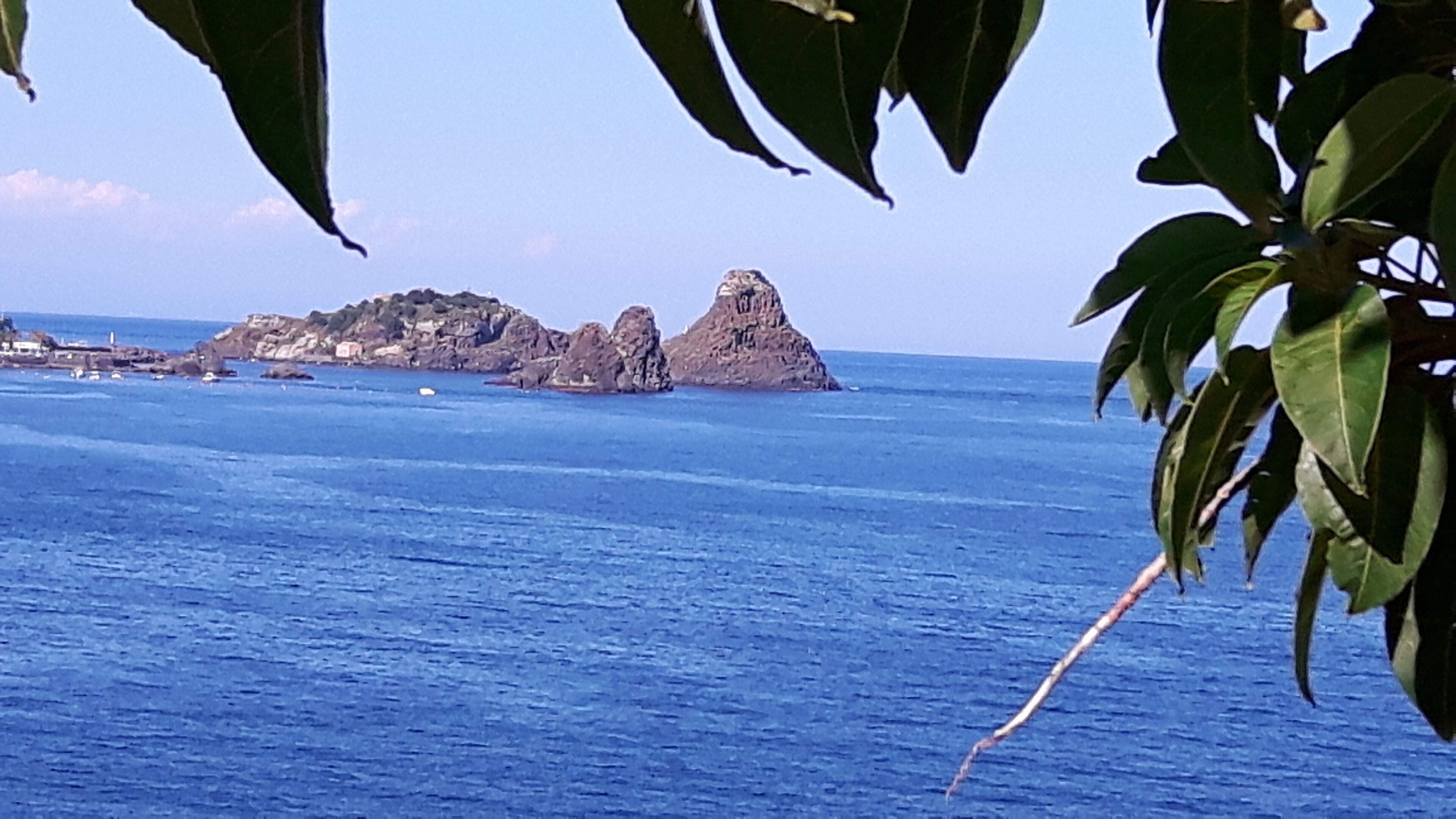 A coastal view with a rocky island and calm sea.