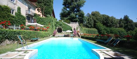 Alberca al aire libre y camastros