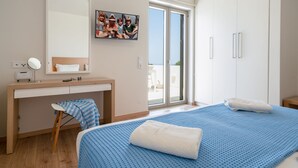 Una camera da letto con un letto, una scrivania, una sedia, uno specchio e una finestra con vista.