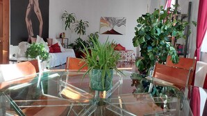 A modern living room with a glass dining table, comfortable seating, and various plants. - Naples Mergellina with charm  (Napoli)