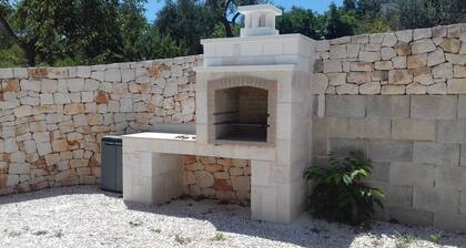Villa en pierre au milieu de la campagne des Pouilles et Ă  quelques kilomĂštres de la mer.