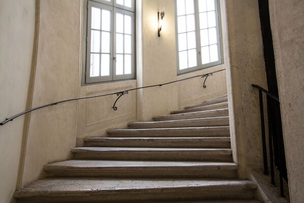 A staircase with a handrail, leading to a landing with two windows. - ALTIERI LOFT PANTHEON (Roma)