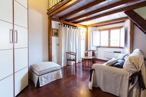 A cozy room with a wooden ceiling, a bed, a sofa, and a chair. - ALTIERI LOFT PANTHEON (Roma)