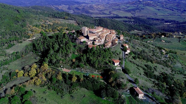 Un castillo medieval rodeado de colinas y valles verdes y exuberantes.