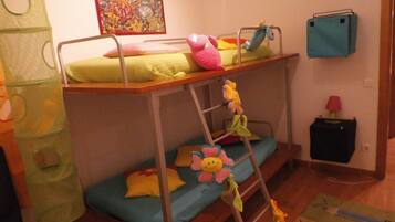 Cozy bunk bed room with a ladder leading to the upper bunk, featuring colorful pillows and a plush toy.