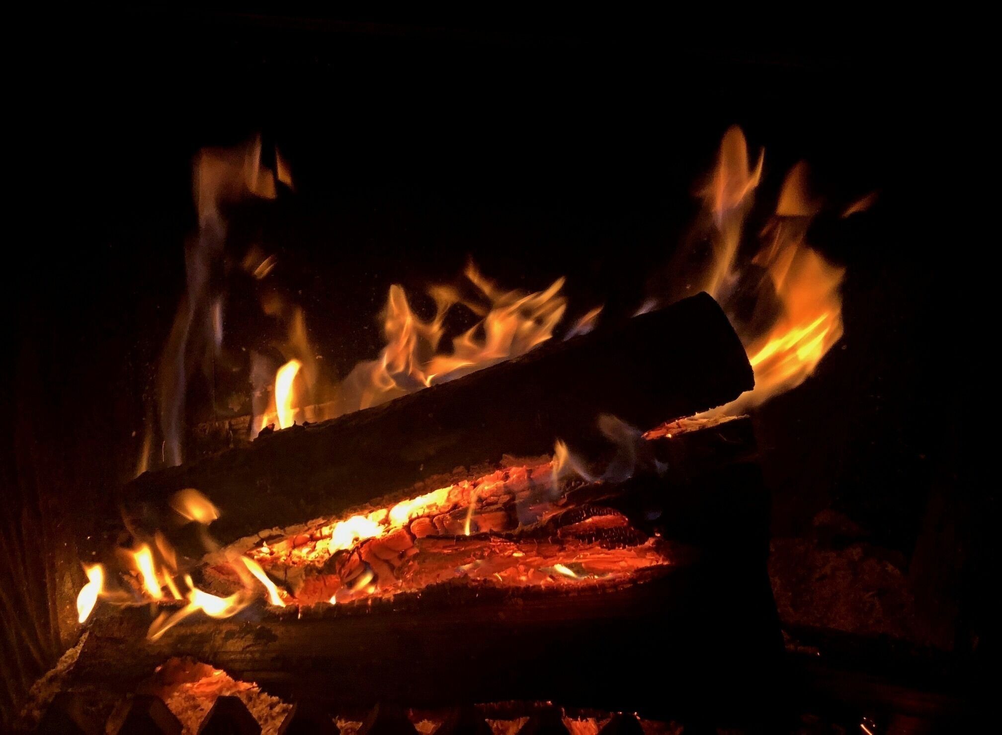 Un gros plan sur des bûches en train de brûler dans le feu.