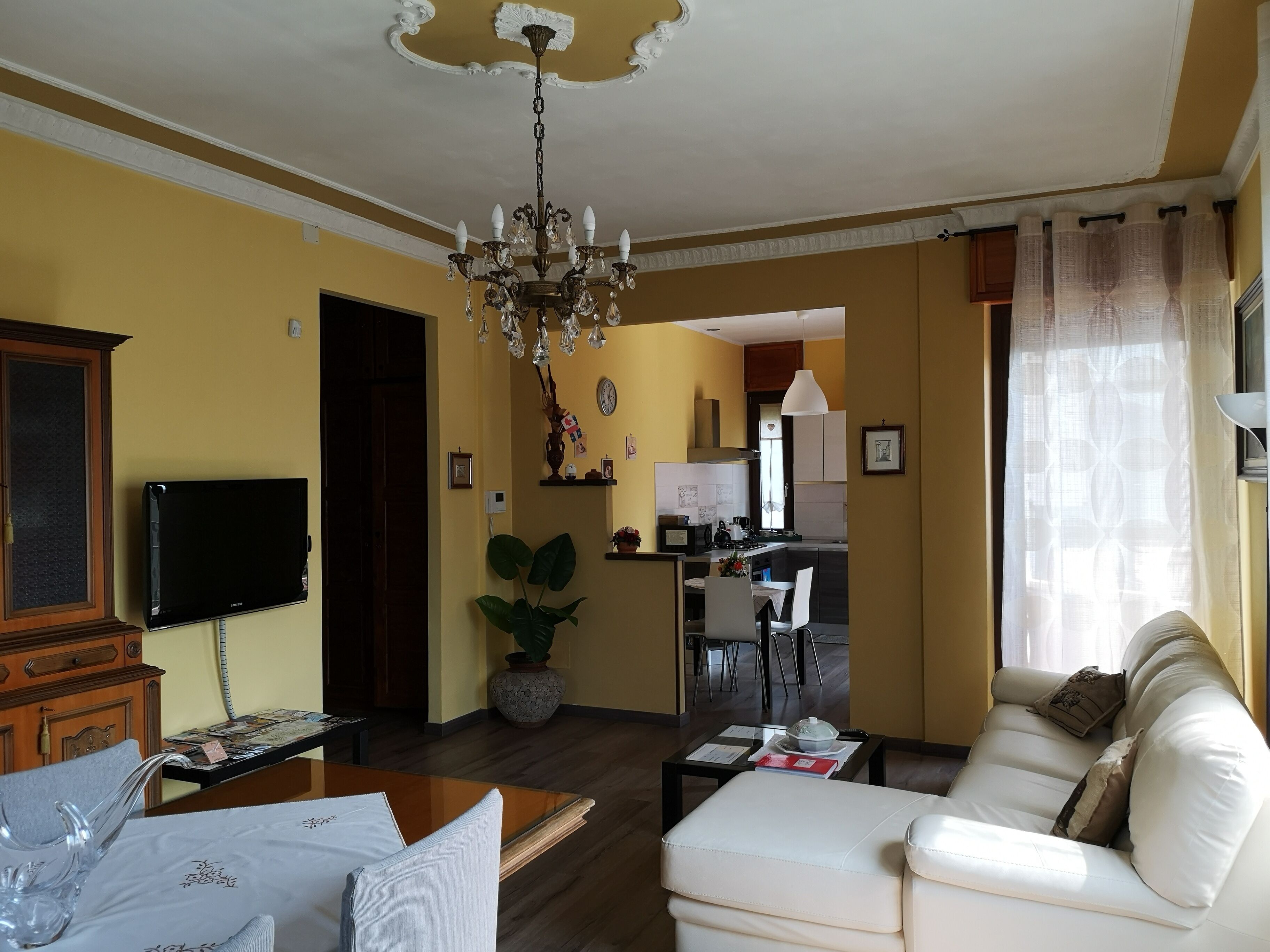 Un salon comprenant un canapé, une table basse, un téléviseur et un lustre.