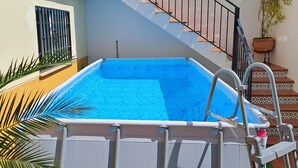 A swimming pool with a metal ladder, surrounded by a white wall and a staircase with a black railing. - Beautiful house in Granada just 10min from the center + (PARKING IN THE CENTER) + WIFI (Ambroz)