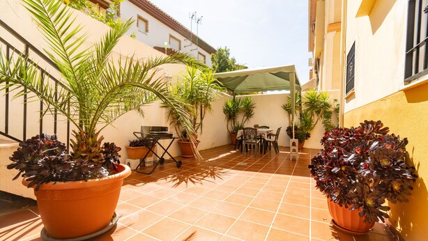 A courtyard with potted plants, a table, and chairs. - Beautiful house in Granada just 10min from the center + (PARKING IN THE CENTER) + WIFI (Ambroz)