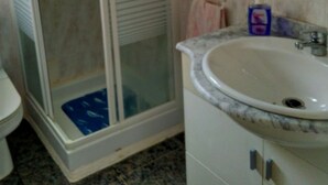 A bathroom with a glass shower enclosure, a sink with a marble countertop, and a toilet. - Taibilla floor (Los Nietos) (Los Nietos)