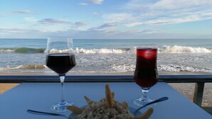 A table with a plate of food and two glasses of red wine, overlooking a beach with waves. - Registered Holiday home in sunny Rojales on the Costa Blanca (Ciudad Quesada)