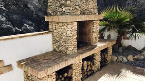 A stone-built outdoor kitchen with a brick countertop and a stone chimney. - Remote mountain villa with stunning views and private pool to sleep up to six (Los Cerricos)