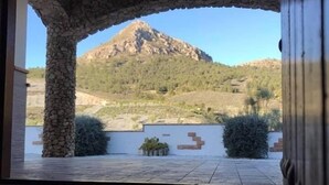 A stone archway leading to a patio with a mountain view. - Remote mountain villa with stunning views and private pool to sleep up to six (Los Cerricos)