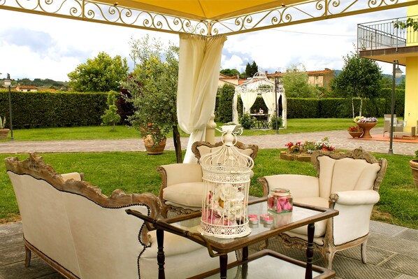 An outdoor seating area with a table, two chairs, and a decorative birdcage.