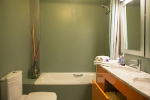 A bathroom with a bathtub, a toilet, a sink, and a mirror. - Nice apartment Seville center with Free Parking (Sevilla)