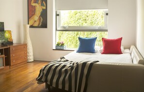 A bedroom with a bed, a window, a dresser, and a painting on the wall. - Nice apartment Seville center with Free Parking (Sevilla)