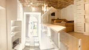 A modern interior with a staircase, a sofa, and built-in shelving. - Vatican Luxury Apartment (Rome)