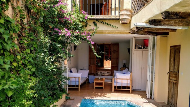 A pool area with a tiled pool, two white sofas, a wooden table, and a wooden door. - Romantic, Moorish house, pool, views, terraces - Lecrin Valley, south of Granada (Saleres)
