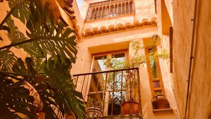 A narrow alleyway with a building featuring a balcony with potted plants and a window. - Romantic, Moorish house, pool, views, terraces - Lecrin Valley, south of Granada (Saleres)