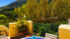 A round table with a blue and white patterned tablecloth, surrounded by yellow walls and wooden furniture. - Romantic, Moorish house, pool, views, terraces - Lecrin Valley, south of Granada (Saleres)