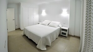 Una camera da letto con un letto, comodini, un armadio e una porta.