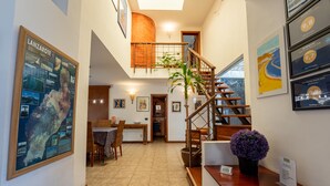 Eine Hotte lobby mit einer Treppe, einem Empfangsbereich und einem Essbereich.