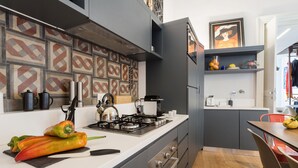 A modern kitchen with a gas stove, stainless steel appliances, and a patterned backsplash. - Uflat • comfy apt, in the historic center of Catania. (Catania)