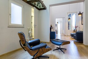 A modern interior with a wooden floor, a blue leather chair, and a blue ottoman.