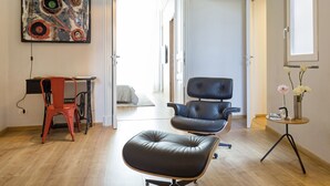 A modern living room with a black leather sofa, a red chair, a desk, and a painting on the wall. - Uflat • comfy apt, in the historic center of Catania. (Catania)
