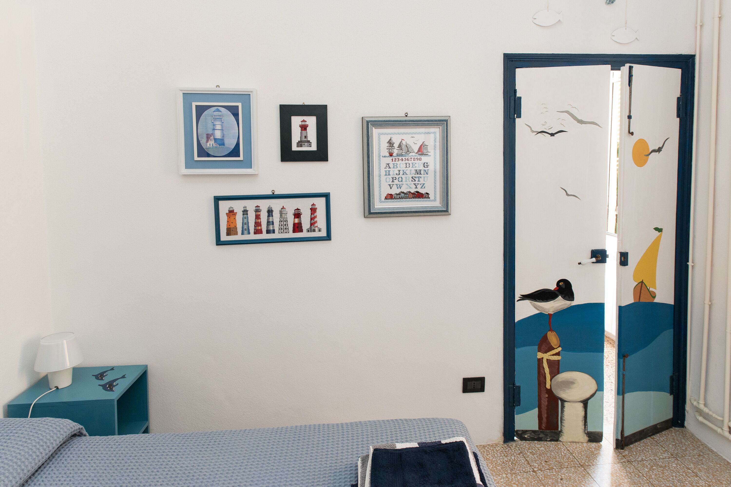 Une chambre à coucher avec un lit, une table de chevet et un mur orné de tableaux.