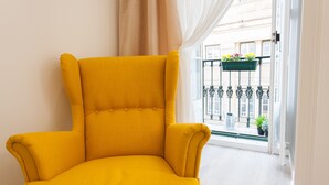 A bright yellow armchair in a room with a balcony.