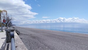 A beach with a concrete barrier, a stop sign, and a clear view of the sea. - A WINDOW ON THE SEA (Roccalumera (ME))