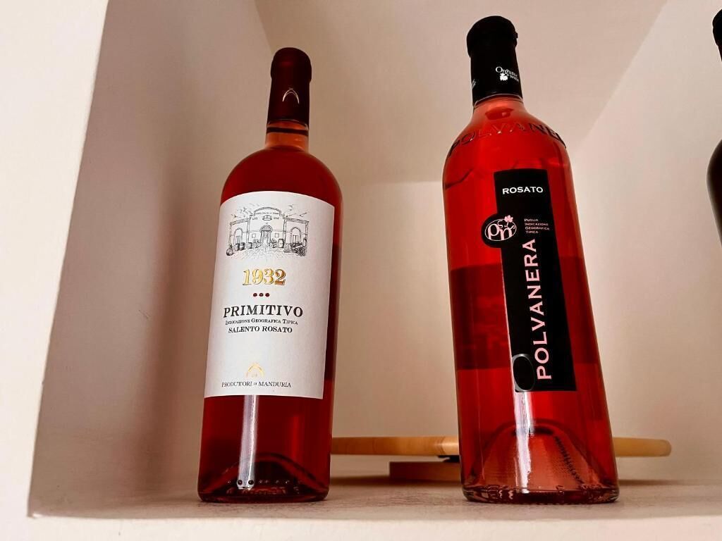 Two bottles of rosé wine, one labeled '1932 PRIMITIVO' and the other 'POLYVANERA'.