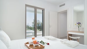 Een hotelkamer met een bed, een ontbijtkar en uitzicht op het omliggende landschap.